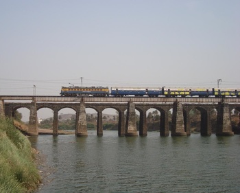 2117 Dn LTT-MMR godavari exp. with lovely WCAM-3 on KALOO viaduct near TITWALA stn. (dp)