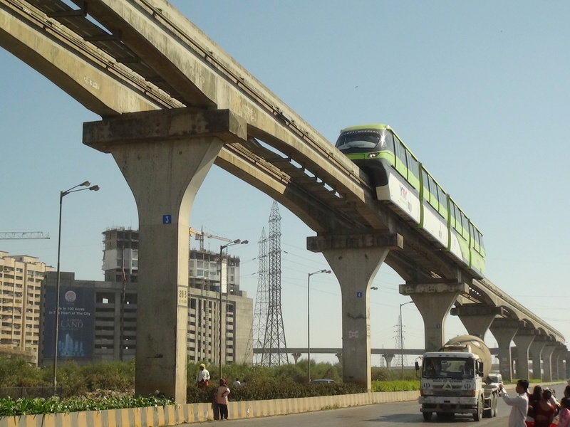 Brand new beautiful Mumbai Mono Rail comes sliding much above the roads majestically near Bhakti Park railway station.  (Arzan K