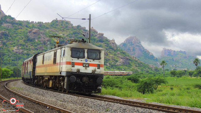 12437 Secunderabad Hazrat Nizamuddin Rajdhani Express negotiates a sweeping curve at Raigir on a rainy day with customary Lallag