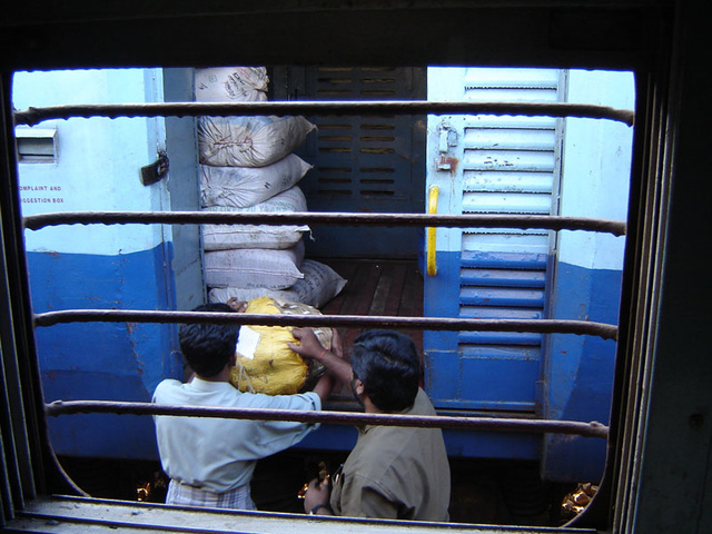 Station staff load a parcel into the SLR of a passenger train